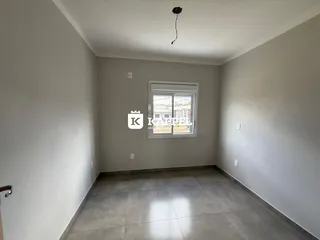 Vista interna de um cômodo com paredes cinzas e piso de porcelanato.