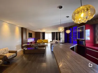 Sala de estar e jantar com piso de madeira e móveis modernos.
