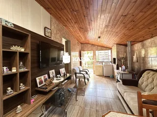 Sala de estar com piso de madeira e teto de madeira aparente.