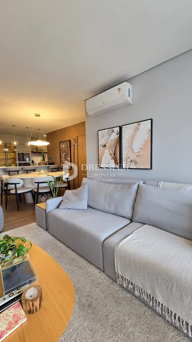 Sala de estar moderna com sofá cinza e decoração contemporânea.