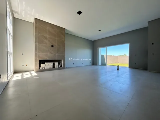 Vista de uma sala ampla com lareira em um imóvel.
