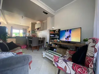 Sala de estar com sofá e televisão em um imóvel no Brasil.