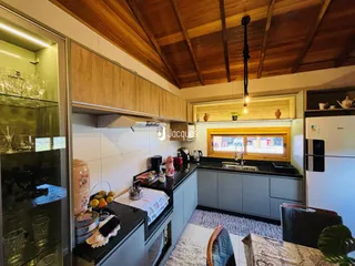 Cozinha moderna com armários de madeira e bancada escura.