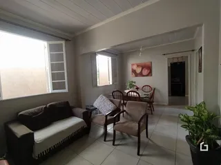 Sala de estar com sofá e mesa de jantar em um imóvel no Brasil.