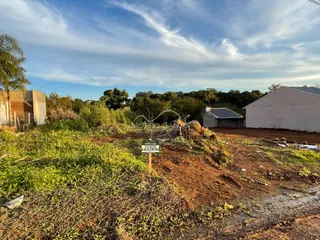 Foto de um lote de terreno aberto com vegetação seca e uma placa de anúncio em Lajeado.