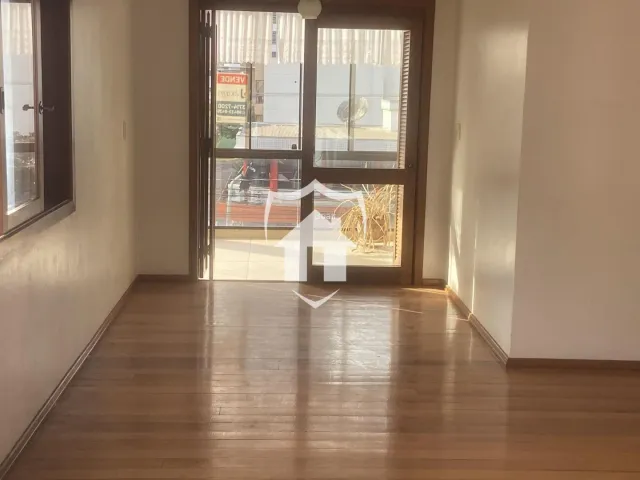Hall de entrada com piso de madeira e portas de vidro.