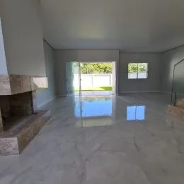 Sala ampla com lareira e piso claro.