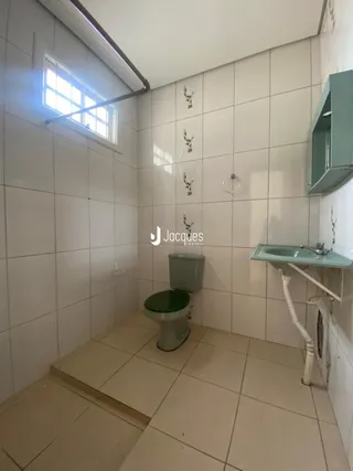 Foto de um banheiro com piso e paredes brancas em cerâmica.