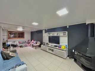 Sala de estar com piso de cerâmica clara e parede escura.
