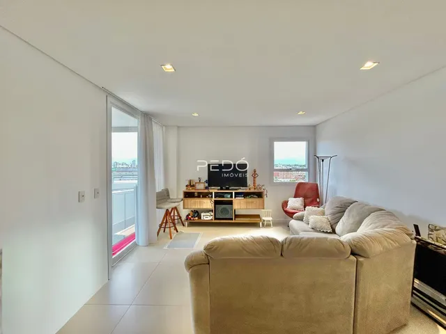 Sala de estar ampla com piso claro e decoração moderna.