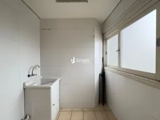 Foto de um banheiro com paredes brancas e revestimento de cerâmica.