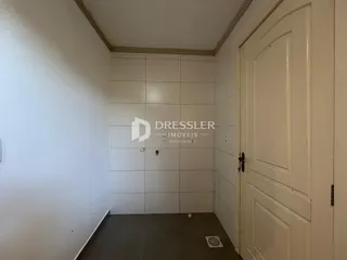 Hall de entrada com paredes brancas e portas brancas.