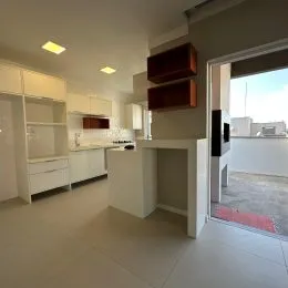 Cozinha com armários brancos e piso claro em um imóvel.