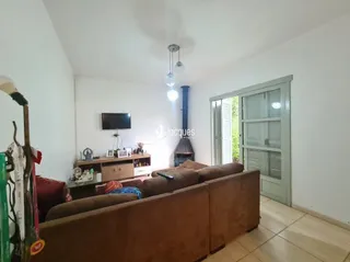 Sala de estar com sofá marrom e televisão na parede.