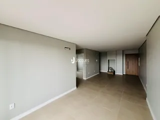 Vista de um corredor interno com paredes brancas e piso de cerâmica.
