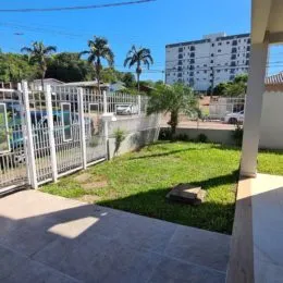 Área externa gramada com cerca branca em um imóvel em Lajeado.