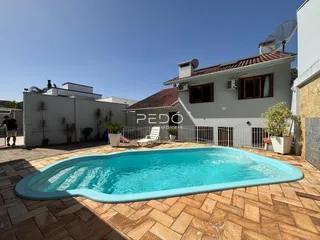 Foto da área externa com piscina e quintal de uma residência em Lajeado.
