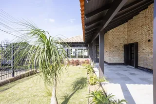 Fachada de casa em Lajeado, Brasil com jardim gramado e área externa coberta.