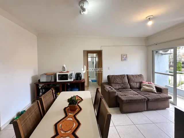 Uma sala de estar com sofá e mesa de jantar em um imóvel no Brasil.