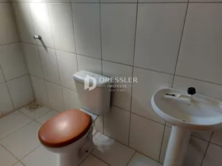 A foto mostra o interior de um banheiro com azulejos brancos.