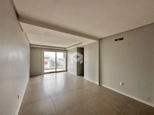 Interior de uma sala com piso claro e paredes brancas.