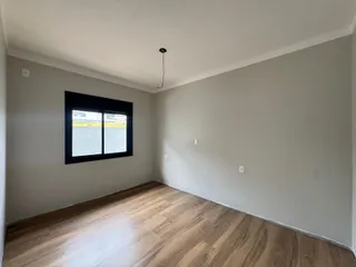 Foto de uma sala de estar com piso de madeira e uma janela.