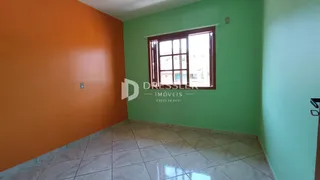 Ambiente interno com paredes em tons de laranja e verde e piso de cerâmica.