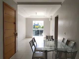 Hall de entrada com porta de madeira e mesa de jantar em um apartamento.