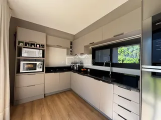 Vista da cozinha moderna com armários cinzas e bancadas escuras.