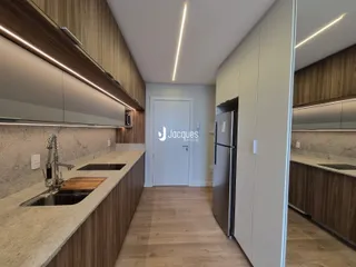 Cozinha moderna com armários de madeira e bancada clara.