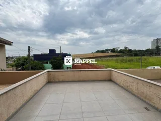 Área externa pavimentada com muros que oferece uma vista da paisagem rural.
