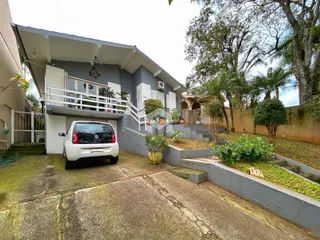 Vista da fachada de uma residência em Lajeado, Brasil, com jardim e garagem.