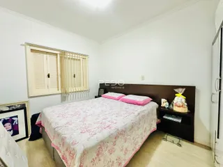 Quarto com cama e janela em ambiente claro.