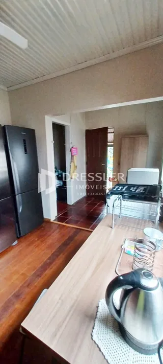 Interior de uma cozinha com piso de madeira e eletrodomésticos modernos.