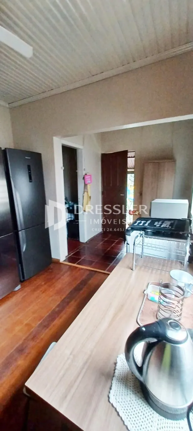 Interior de uma cozinha com piso de madeira e eletrodomésticos modernos.