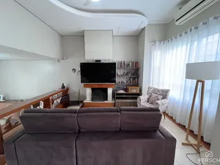 Sala de estar com sofá e lareira em ambiente claro.