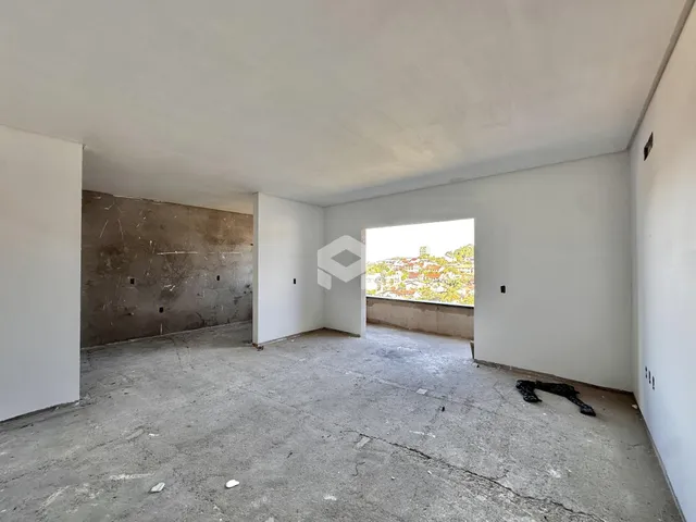 Espaço interno com piso de concreto e paredes brancas em uma residência.