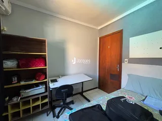 Quarto com estante e porta de madeira em um imóvel.