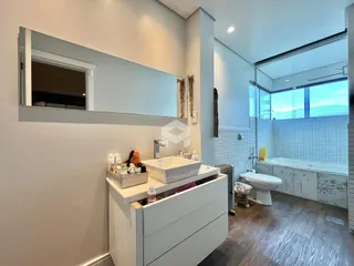 Foto de um banheiro moderno com revestimento cerâmico e piso de madeira.