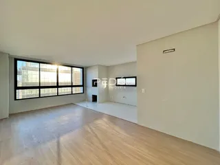Sala de estar ampla com grande janela de vista para a cidade.
