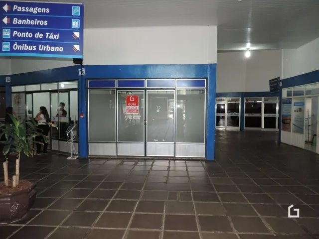 Corredor de entrada com portas de vidro e sinalização de transporte público.