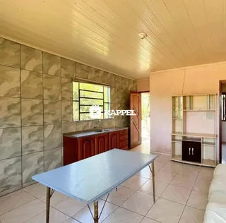 Foto de um ambiente interno com mesa de jantar e revestimento de pedra nas paredes.