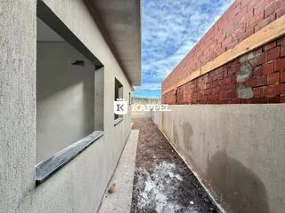 Fachada lateral de uma construção com paredes de alvenaria e tijolos aparentes.