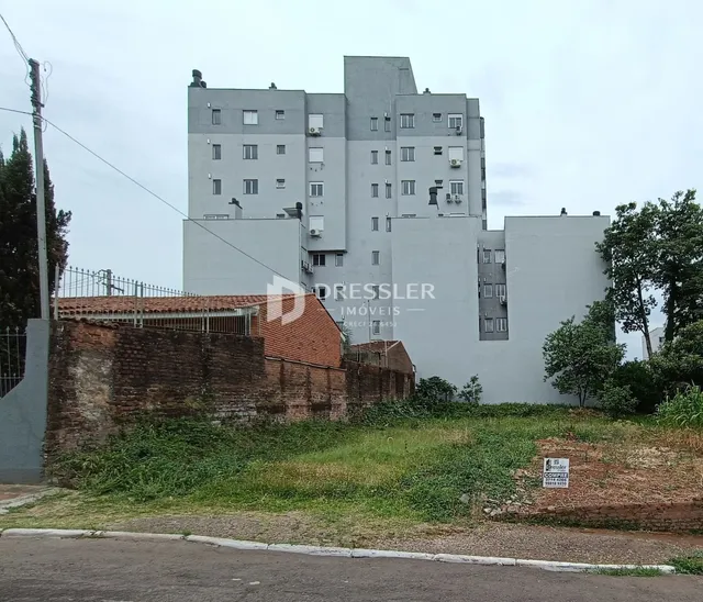 Fachada de um prédio residencial em Lajeado, Brasil, com muro de tijolos no primeiro plano.