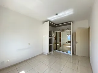 Interior de um ambiente com paredes brancas e piso de cerâmica clara.