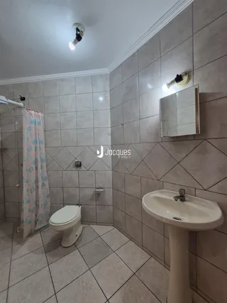 Foto de um banheiro com piso e paredes revestidos de cerâmica.