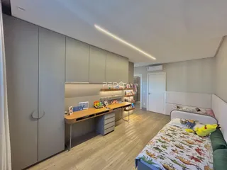 Quarto moderno com armários e cama em um imóvel no Brasil.