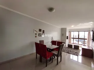 Sala de jantar com mesa e cadeiras em um ambiente claro.