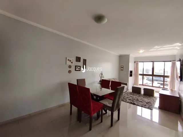 Sala de jantar com mesa e cadeiras em um ambiente claro.