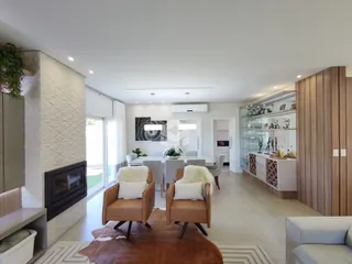 Sala de estar e jantar moderna com luz natural e lareira.